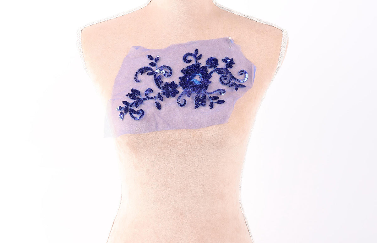 A mannequin torso with a piece of fabric or material attached to it, featuring a floral pattern in blue and purple colors.