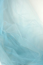The image is a close-up of a light blue, sheer fabric, with its delicate and flowing texture.