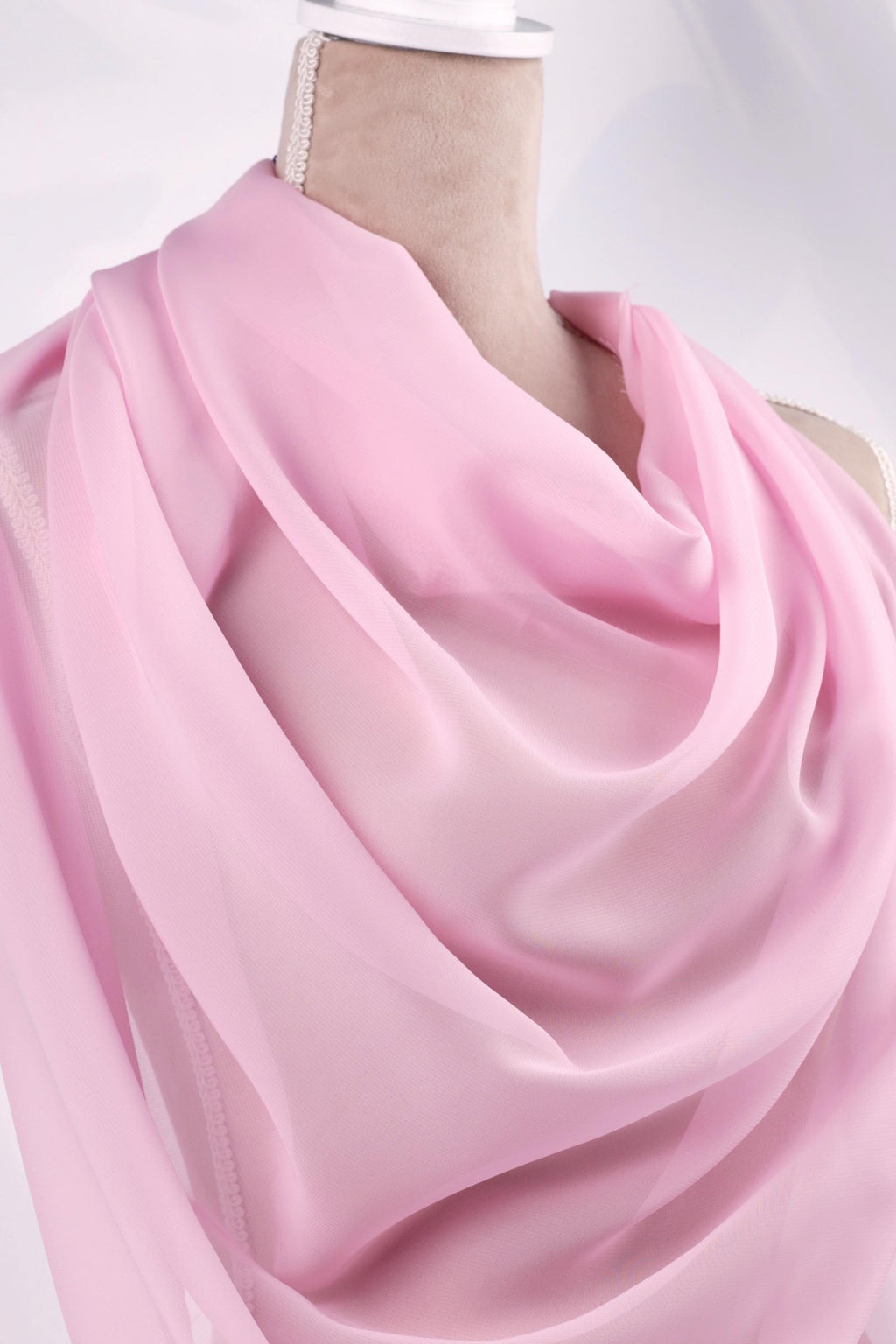 A mannequin wearing a pink satin scarf.