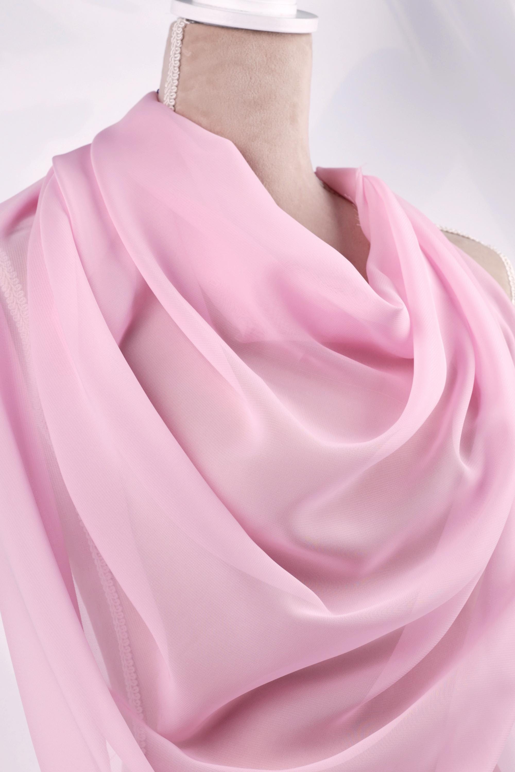 A mannequin wearing a pink satin scarf.