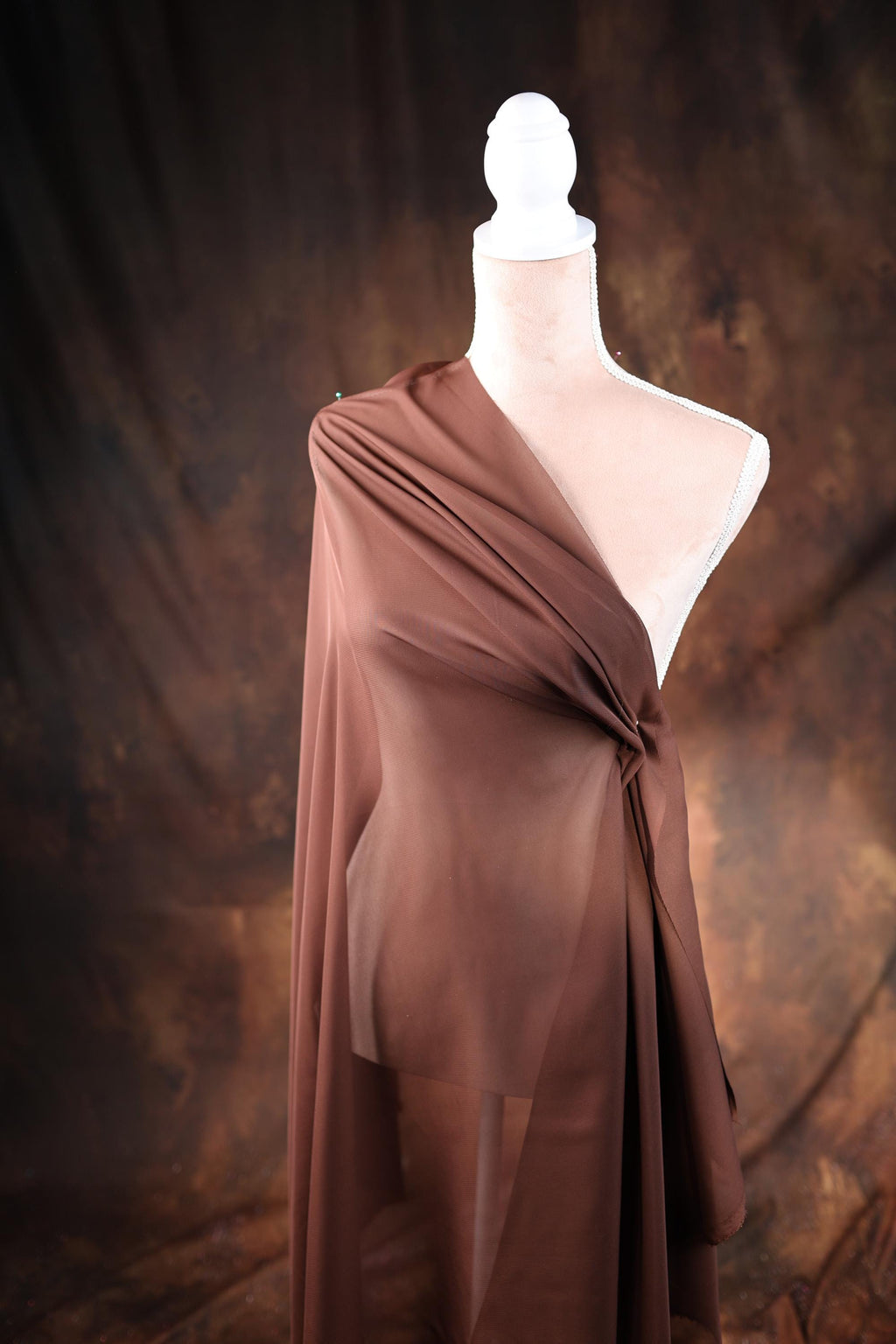 a mannequin wearing a brown draped dress