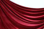 a close-up view of a red velvet curtain, with its folds and creases visible.