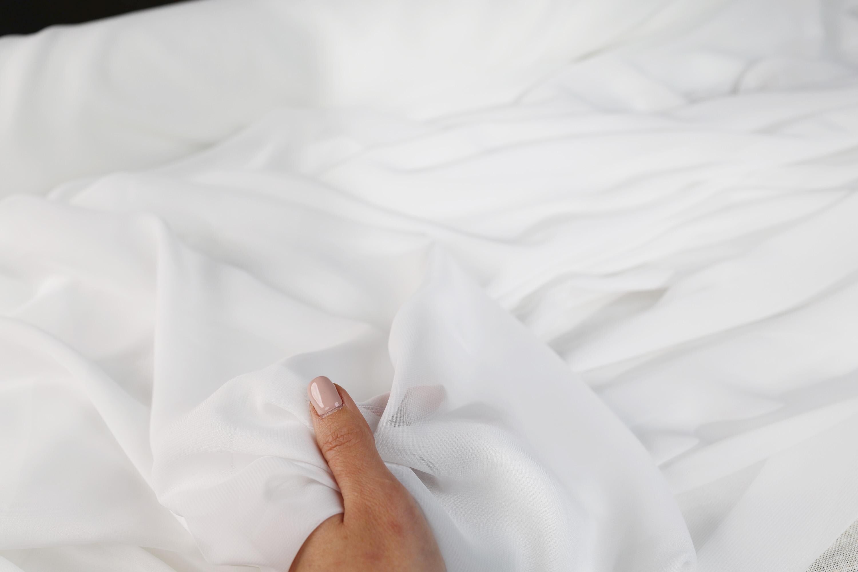 A hand is holding a white sheet of paper, with the fingers curled around it.