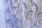 a close-up view of a fabric with a floral pattern and sequin details. The fabric appears to be a sheer material, with a blue and purple color scheme. The pattern consists of various floral motifs and sequin elements, creating a visually striking and intricate design.
