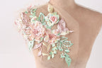 A mannequin torso with a delicate floral embroidered on the shoulder.