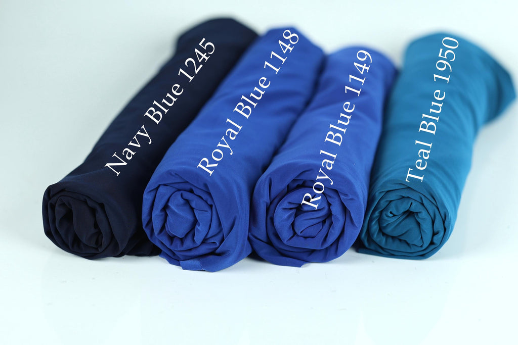 four rolled-up blue fabric pieces, each with a different color label indicating the color of the fabric.