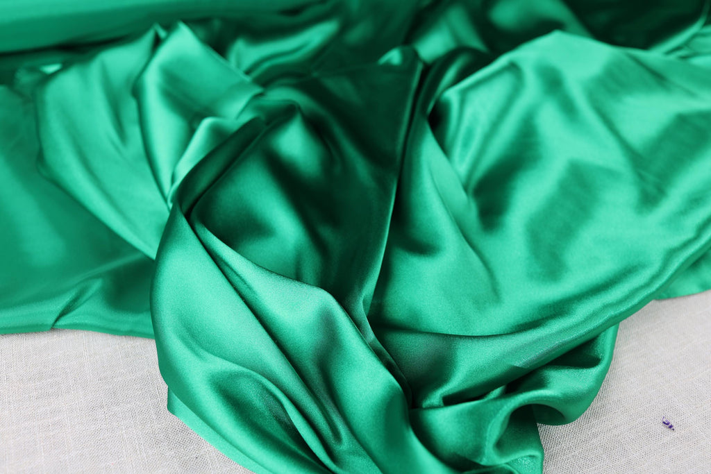 a close up of a green cloth on a bed