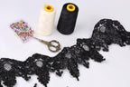 sewing supplies, including two spools of thread, a pair of scissors, and a spool of thread with a yellow tip, arranged on a white background.
