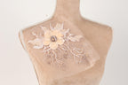 A mannequin torso with a delicate, intricate floral embroidery on the bust area.