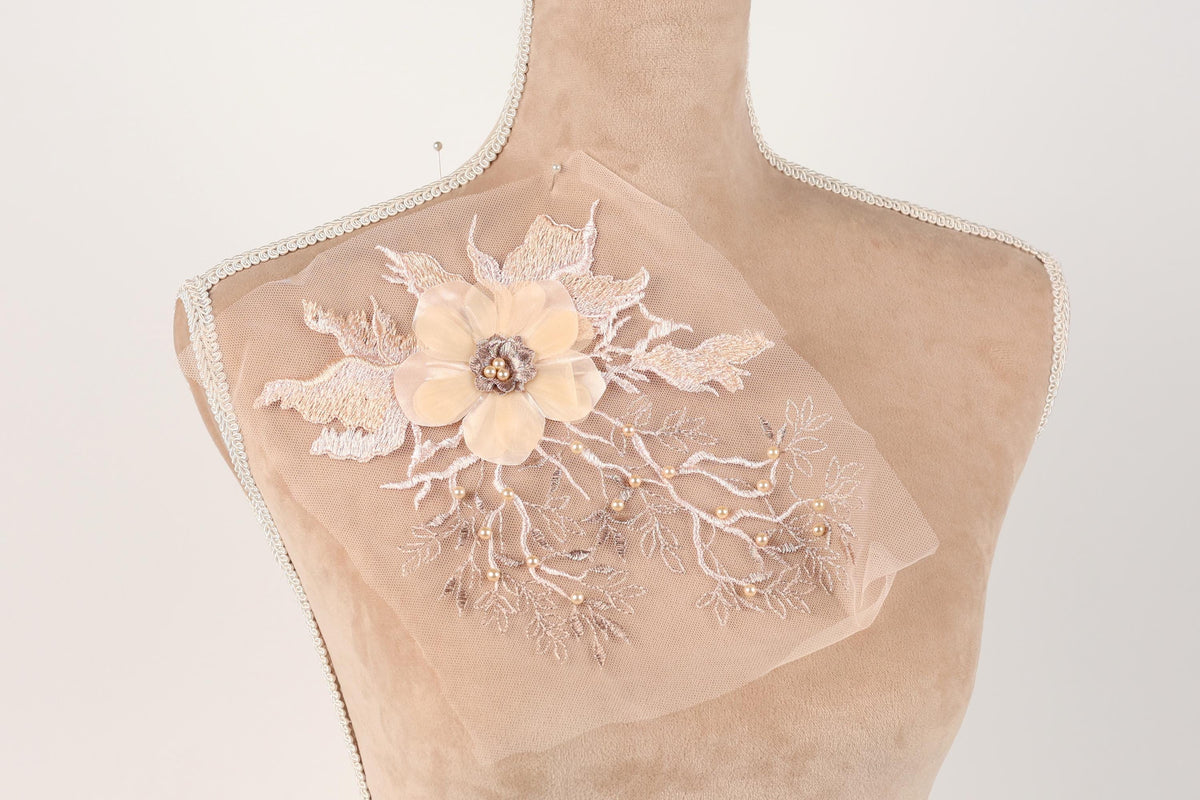 A mannequin torso with a delicate, intricate floral embroidery on the bust area.