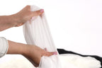 A person's hands holding a white cloth against a white background.