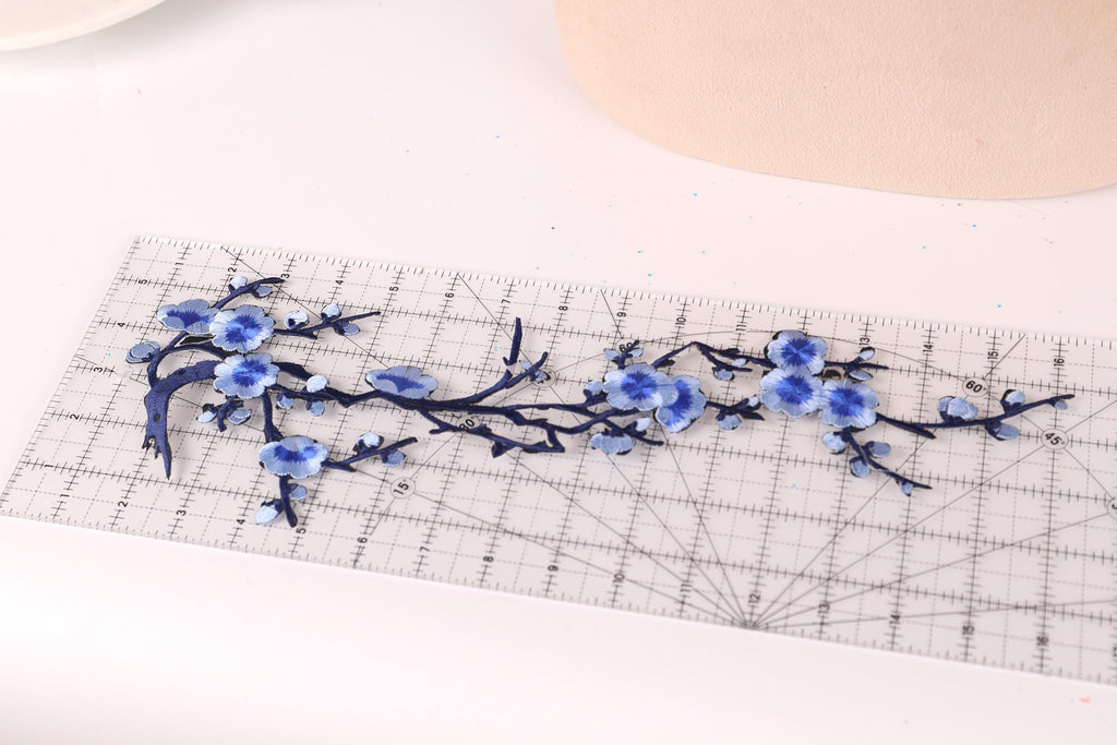 a clear ruler with blue floral designs on it, placed on a white surface.