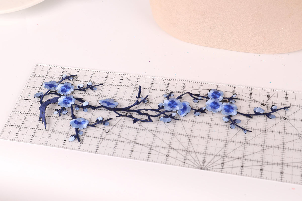 a clear ruler with blue floral designs on it, placed on a white surface.