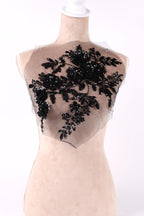 A mannequin wearing a dress with a black floral pattern on the bust area.