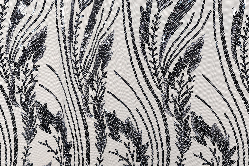 a close-up view of a fabric with a repeating pattern of black and white lines and shapes, resembling a floral or leaf-like design.