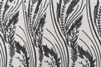 a close-up view of a fabric with a repeating pattern of black and white lines and shapes, resembling a floral or leaf-like design.