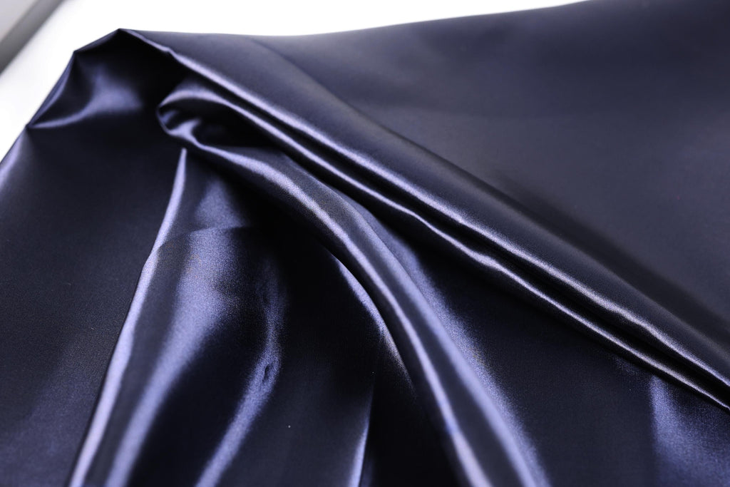 a close-up view of a shiny, dark blue satin fabric.