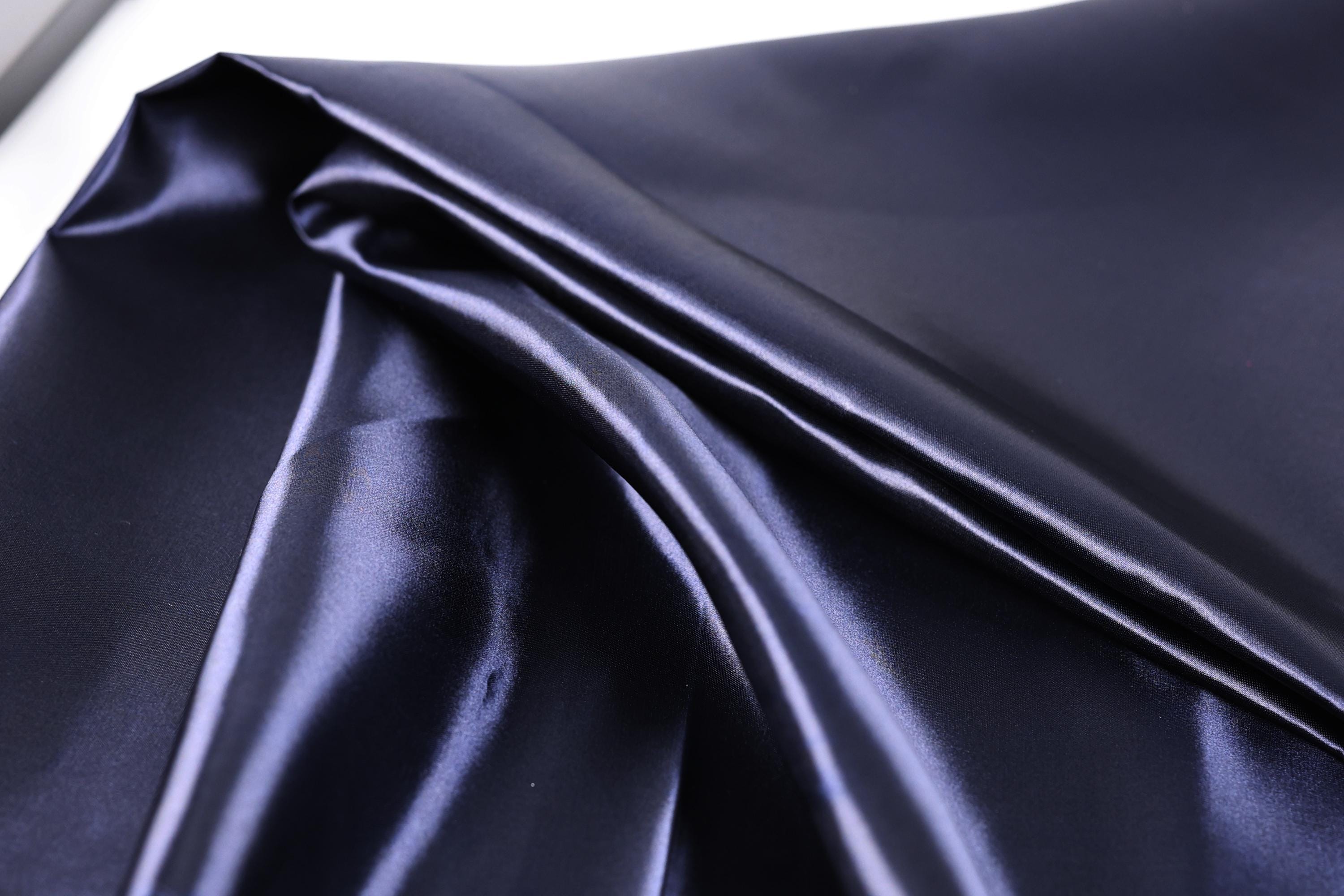 a close-up view of a shiny, dark blue satin fabric.