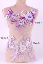 A mannequin with a dress featuring a floral design in shades of purple and white. The dress has a sheer, lace-like fabric with various floral patterns and accents.