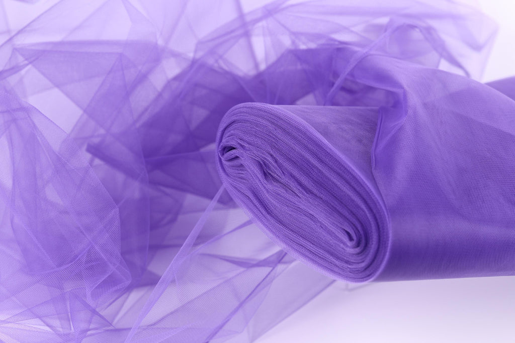 A close-up view of a piece of purple tulle fabric, with its delicate and flowing texture visible.