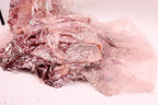 a pile of pink and white fabric with sequins and lace-like patterns, creating a visually appealing and intricate design.