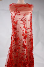 A red dress with a floral pattern on the front, featuring red flowers and leaves.