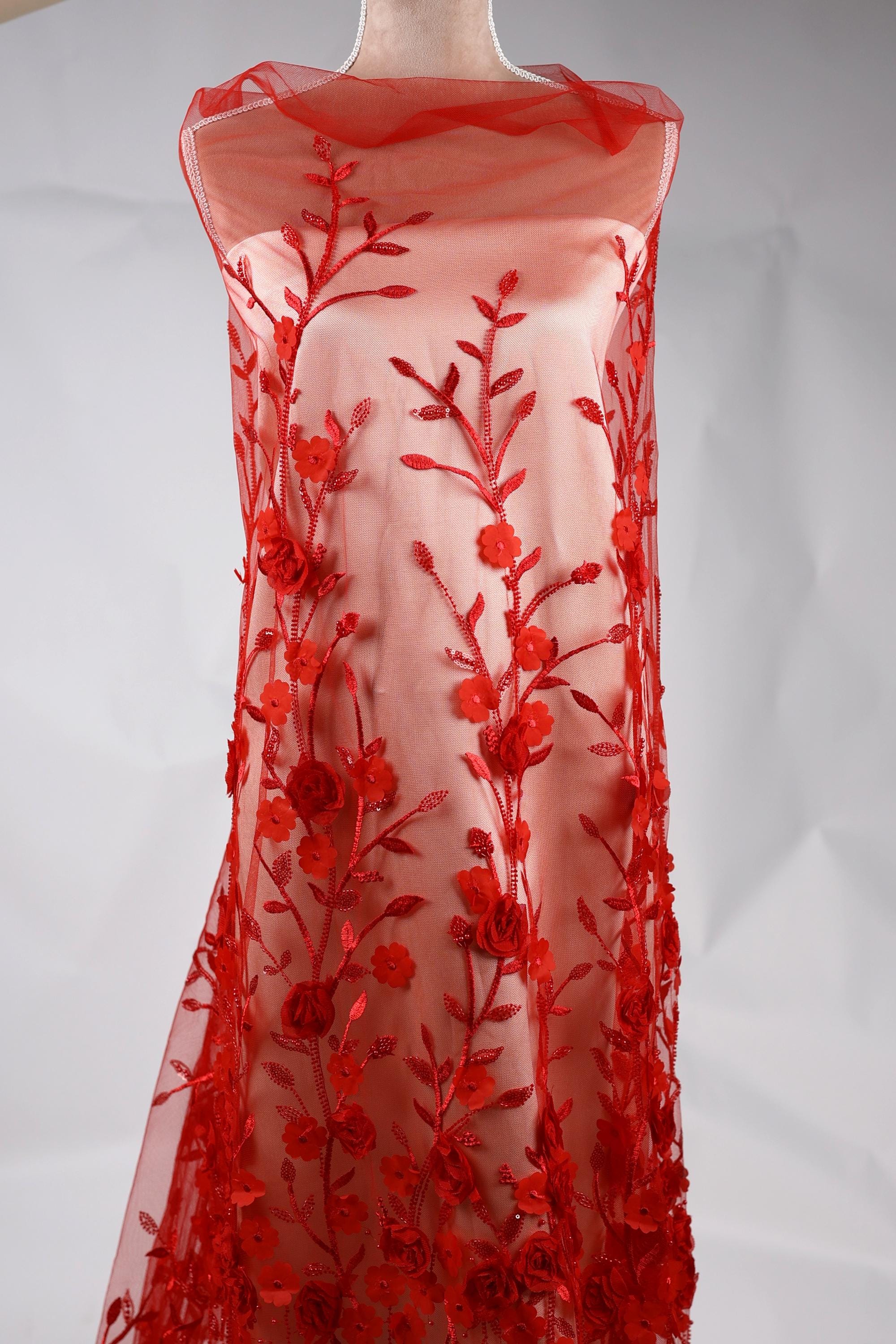 A red dress with a floral pattern on the front, featuring red flowers and leaves.