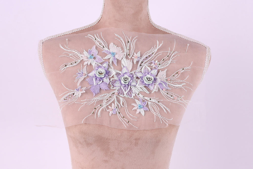 A mannequin with a delicate floral embroidered on its shoulder.