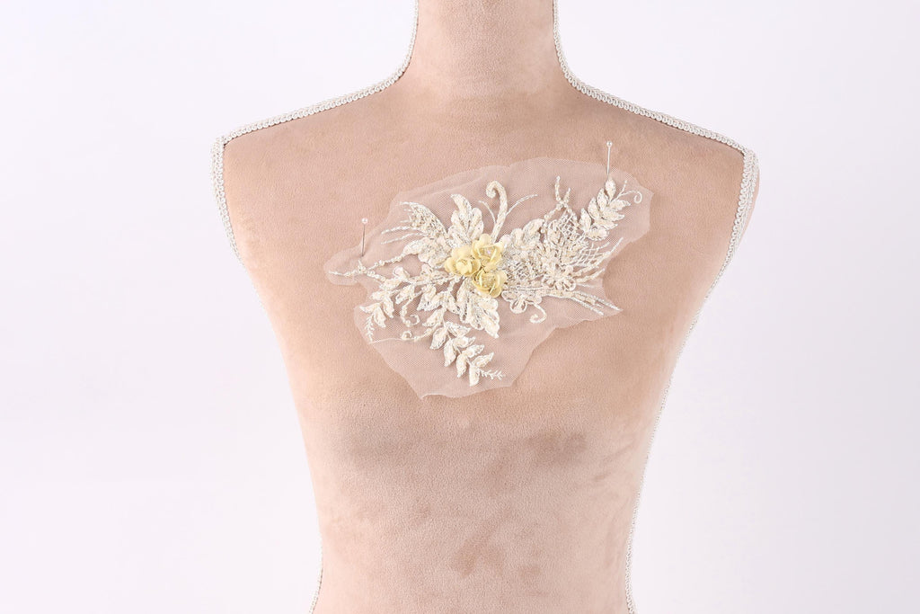 A mannequin torso with a delicate, floral-patterned fabric attached to it.