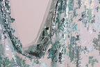 a close-up view of a fabric with a floral pattern and sequin details, creating a visually appealing and intricate design.