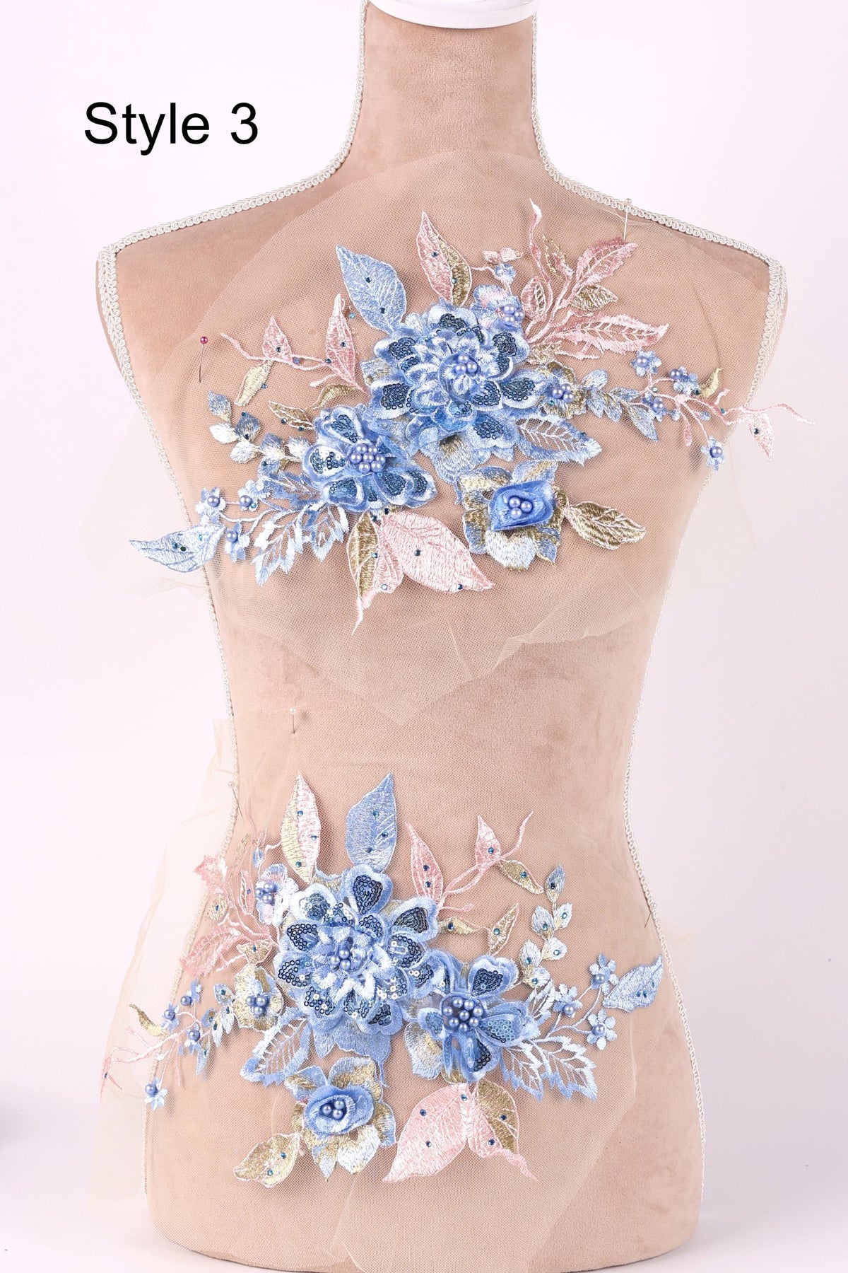 A mannequin with a floral design on its bust, featuring blue and pink flowers and leaves.