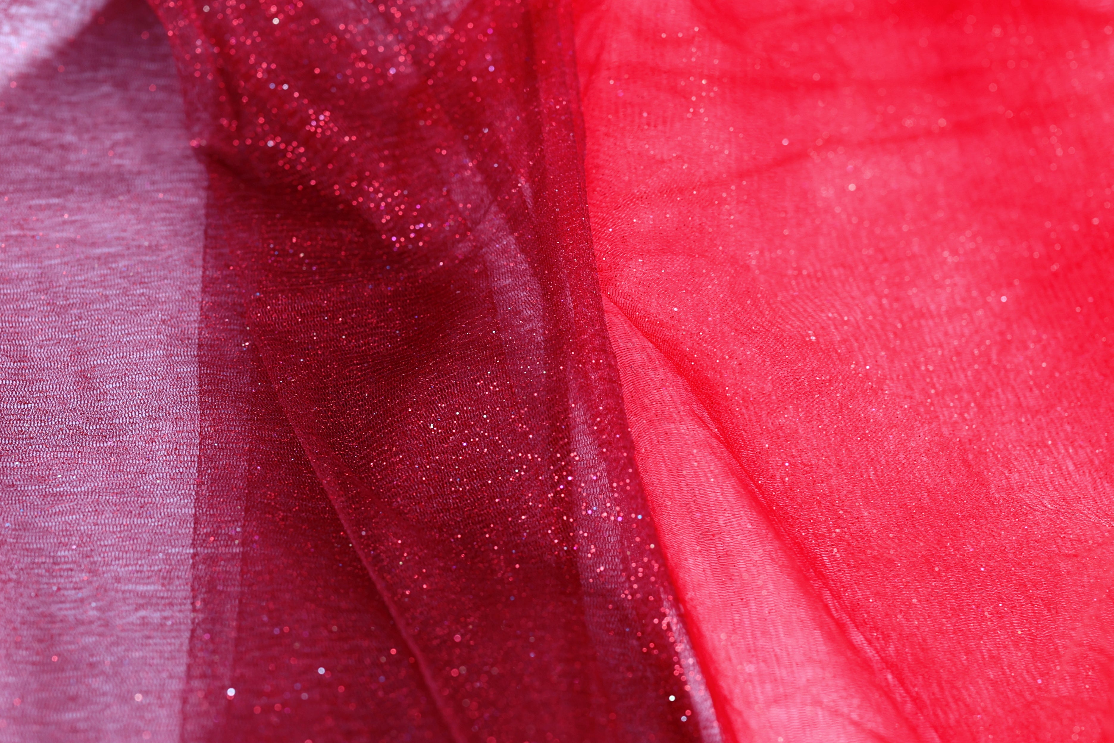 a close-up view of a red fabric with a glittery texture, creating a visually striking contrast.