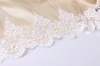 A close-up view of a delicate, white lace trim on a fabric, with intricate patterns and designs.