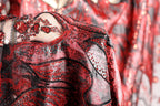 a close-up view of a red and black sequined dress with intricate patterns and designs.
