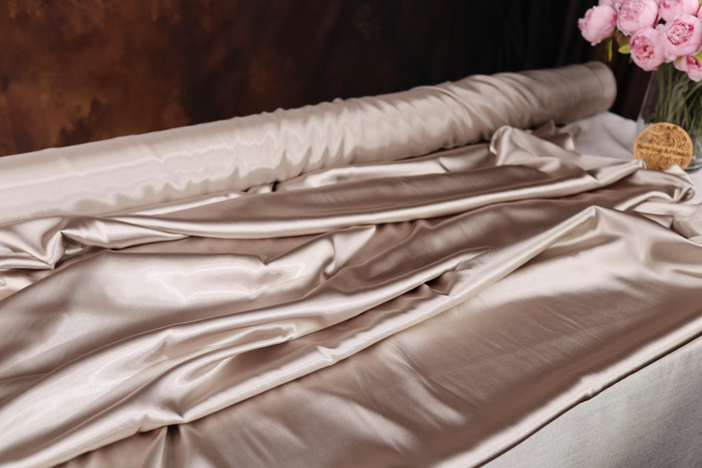 a vase filled with pink flowers sitting on top of a bed