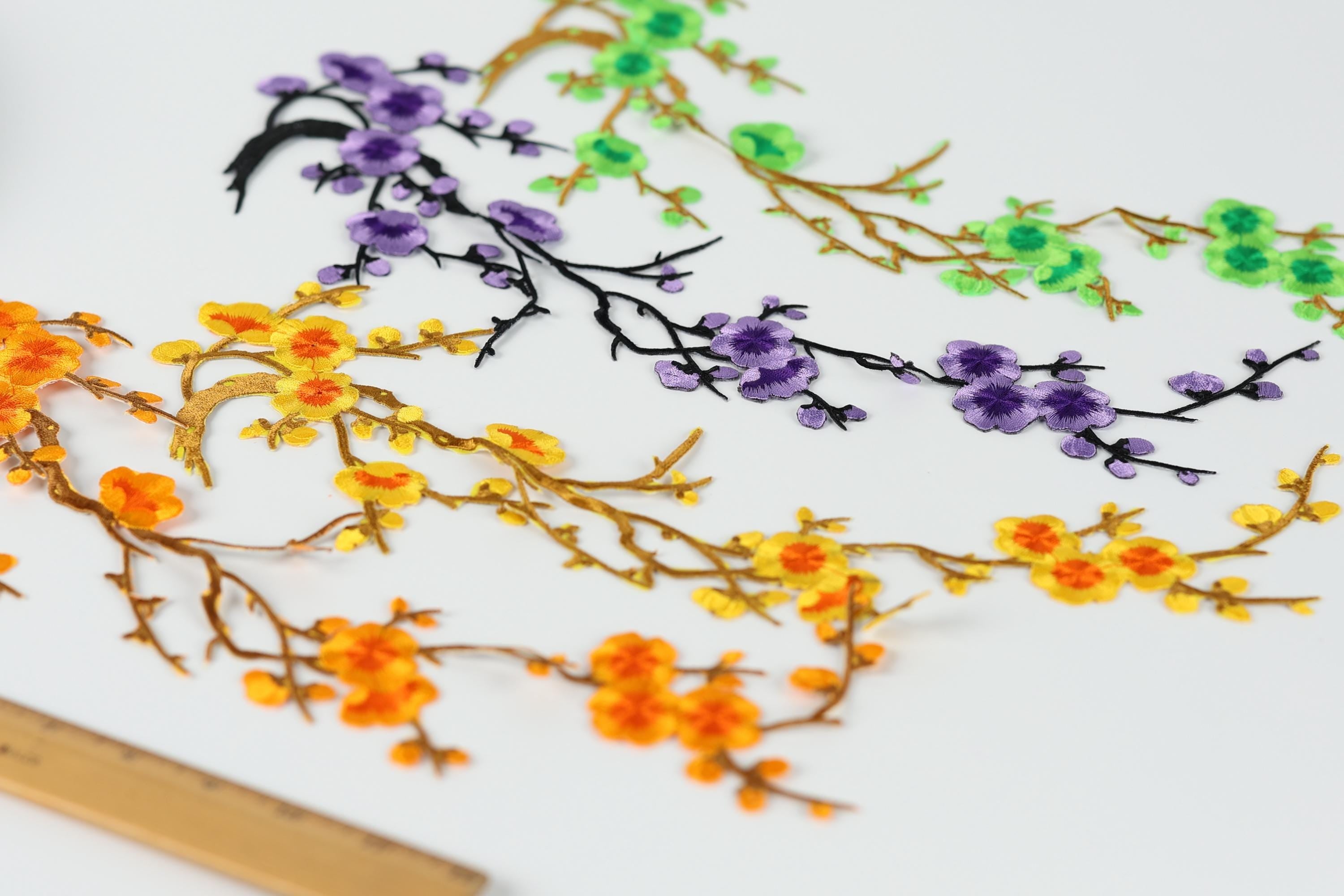 a variety of colorful flowers and branches, including orange, yellow, purple, and green flowers, arranged in a visually appealing manner.