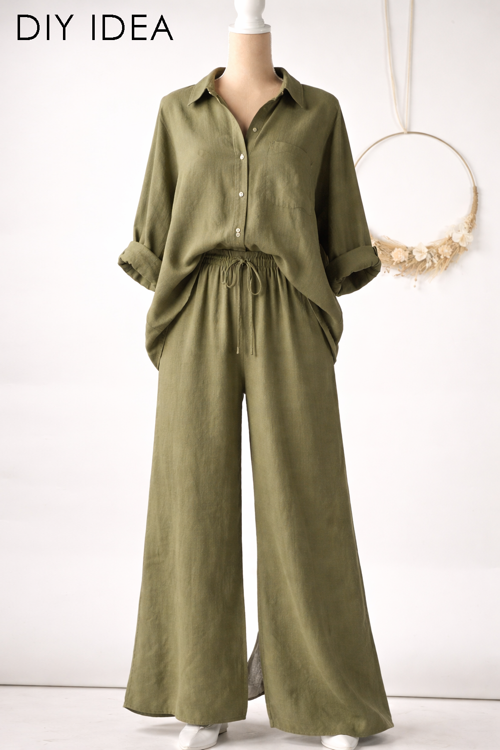 a mannequin wearing a green button-up shirt and wide-leg pants.