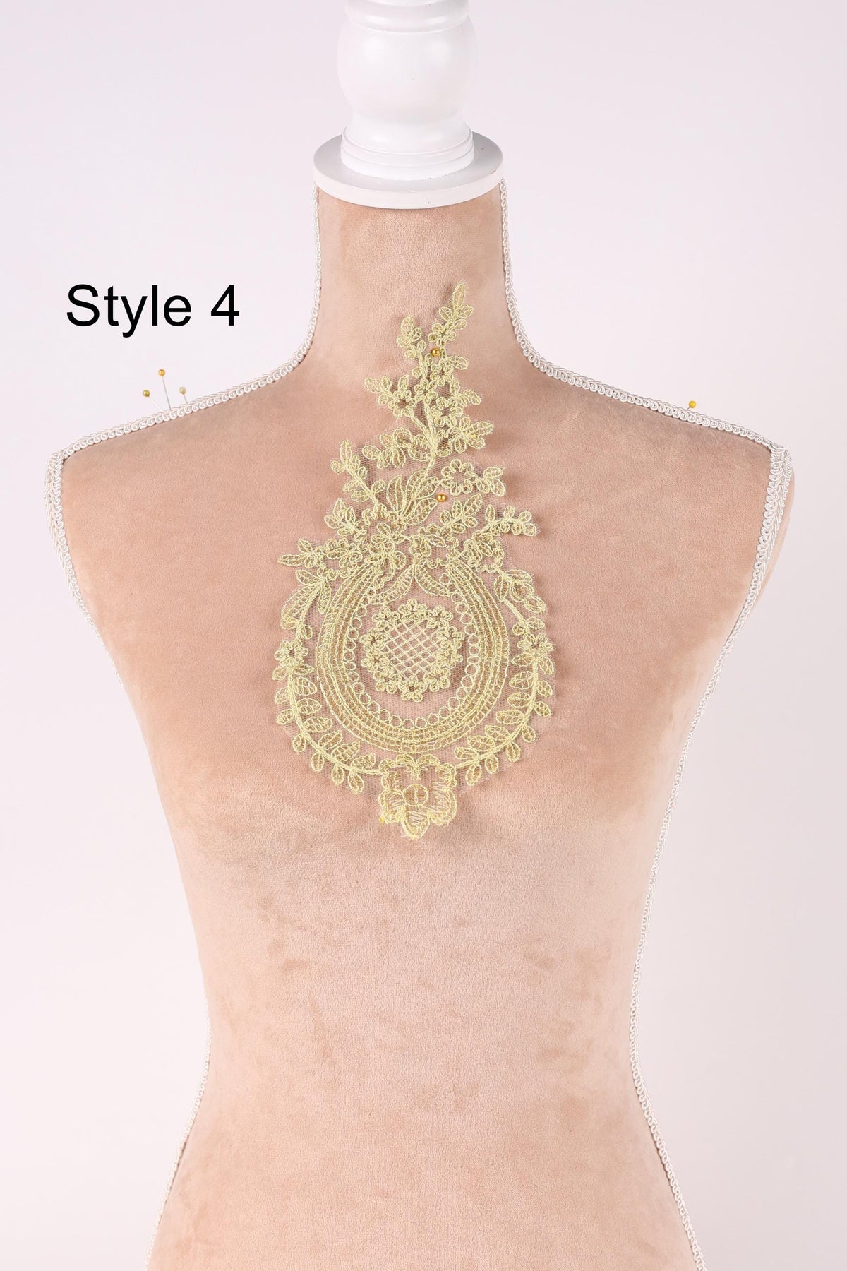 A mannequin with a decorative yellow lace piece on its bust, displayed against a plain background.