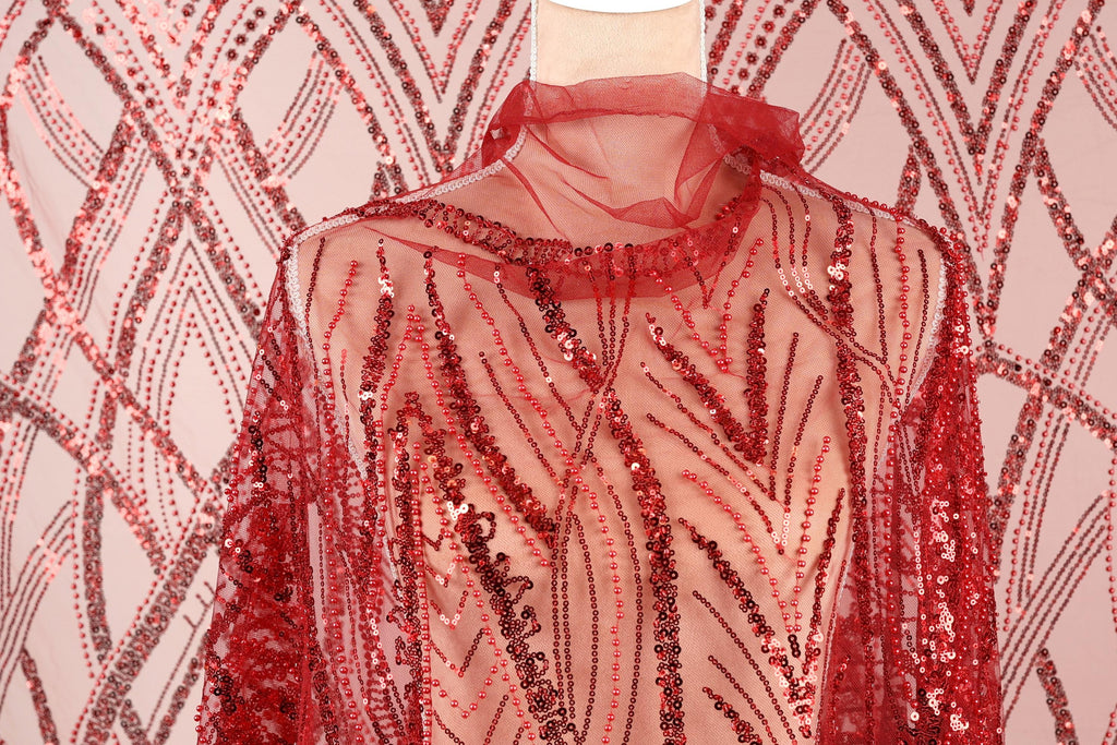 a mannequin wearing a red sequin dress with a sheer overlay.