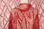 a mannequin wearing a red sequin dress with a sheer overlay.