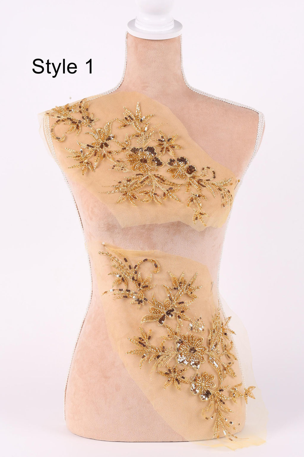 A mannequin with a beige fabric body and gold floral embroidery on the bust and waist areas.