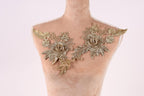 A mannequin with gold embroidered flowers on its shoulders.