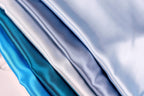 A close-up image of a collection of fabric swatches in various shades of blue, including light blue, dark blue, and a darker shade of blue.