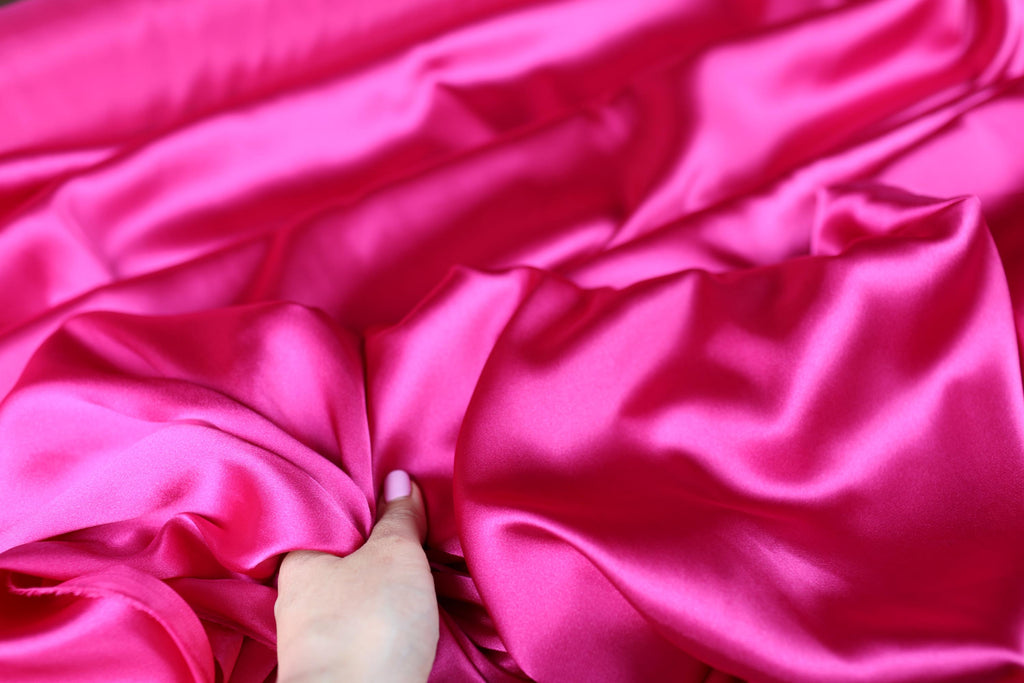 a person is laying down with a pink blanket