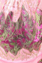 The image is a close-up of a pink and green sequined dress, showcasing intricate patterns and designs.