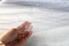 a person's hand holding a piece of clear material