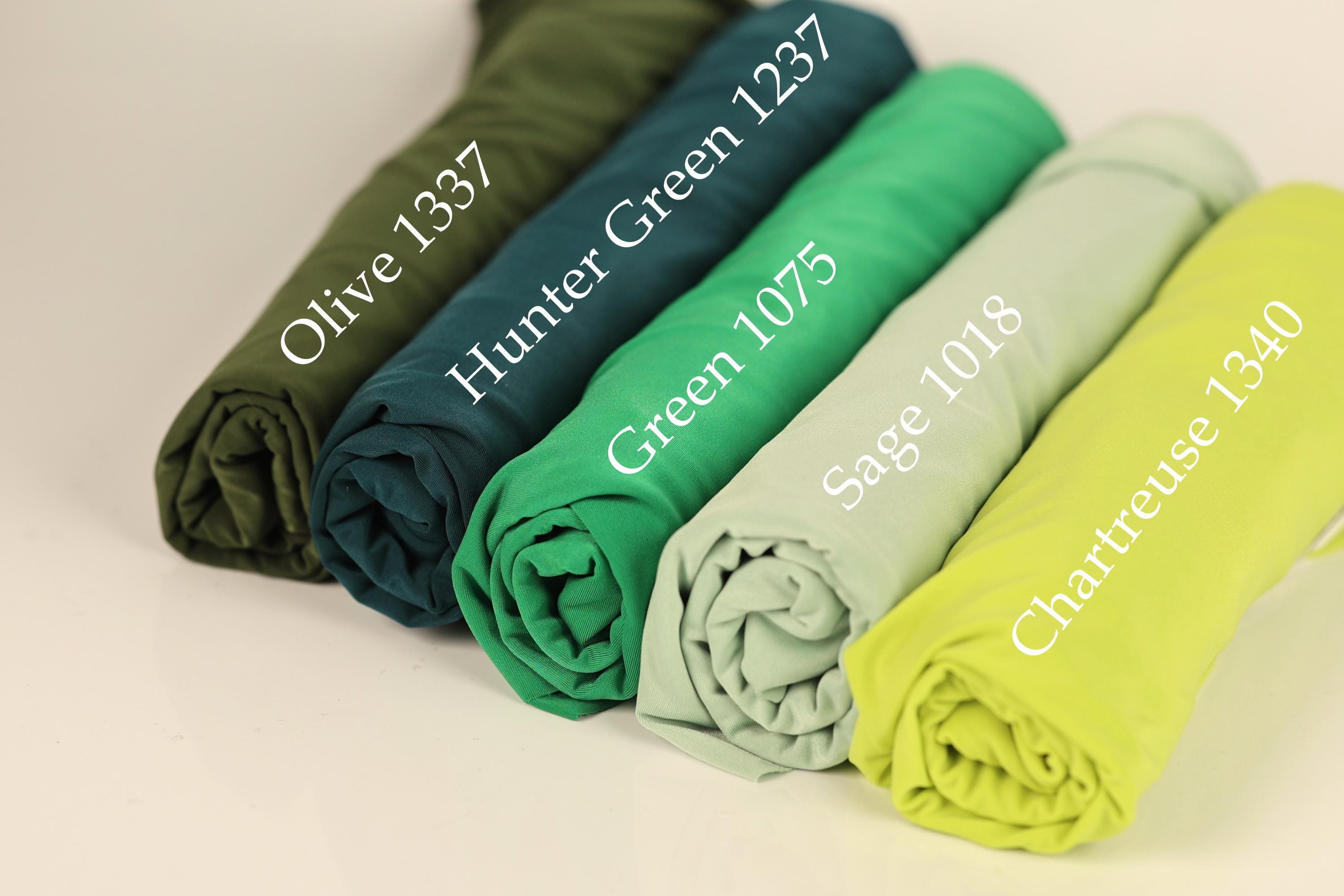 a collection of five rolled-up fabric swatches in various colors, including olive green, green, green, green, and yellow.