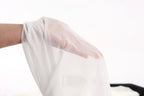A hand is holding a white fabric, possibly a sheer or sheer-like material, against a plain white background.