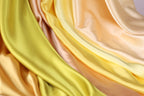 The image is a close-up of a fabric with a vibrant yellow and peach color gradient, creating a visually appealing and textured appearance.