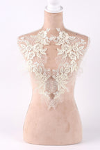 A mannequin with a lace bodice featuring intricate floral designs.